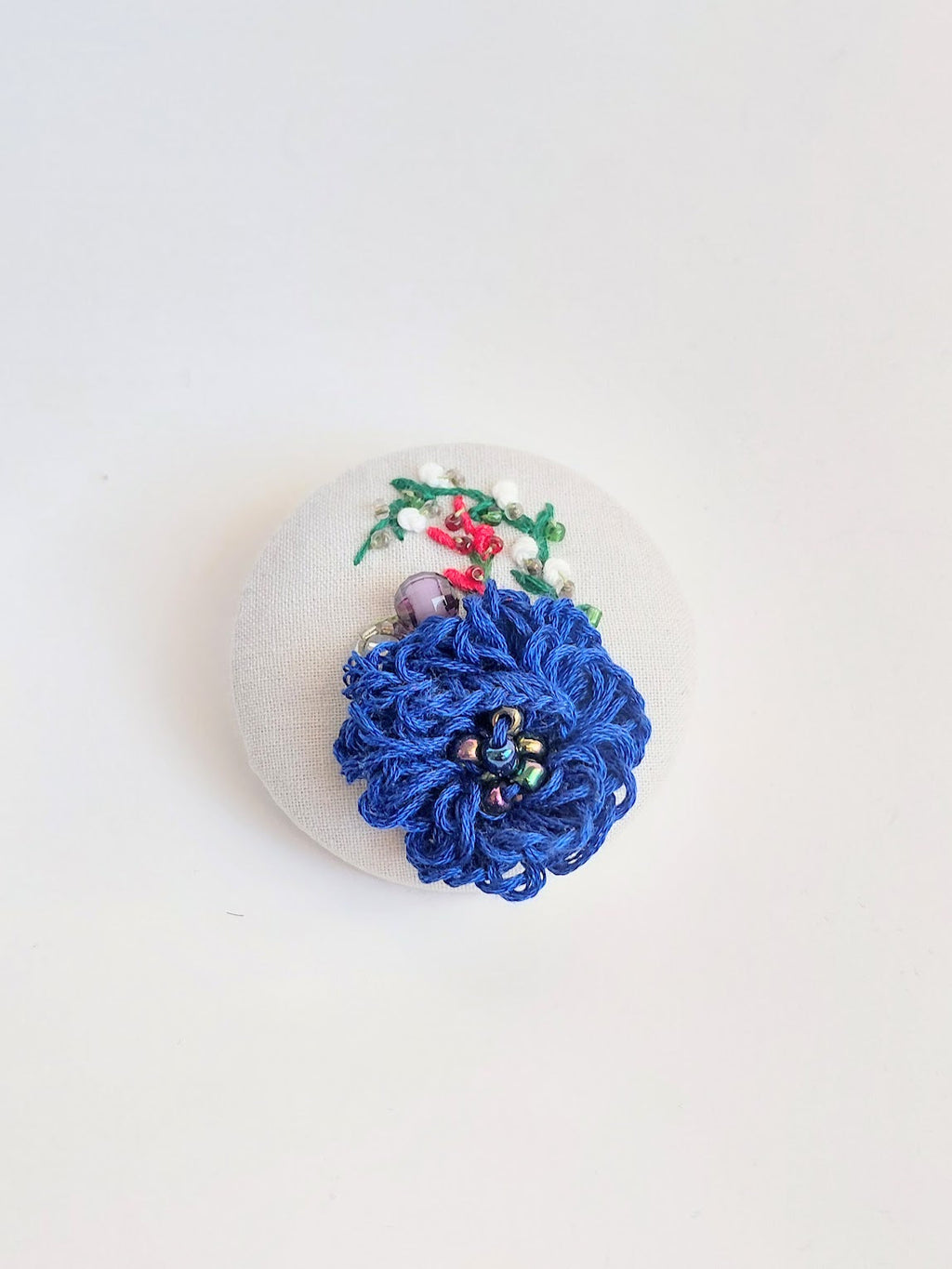 Decorative blue flower brooch on white background