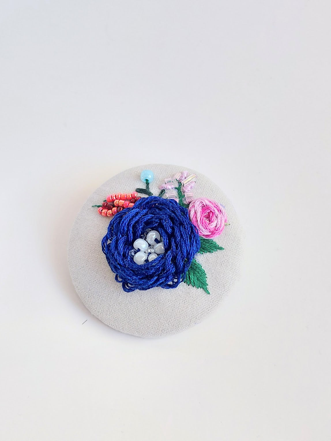 Decorative blue flower brooch on light blue background
