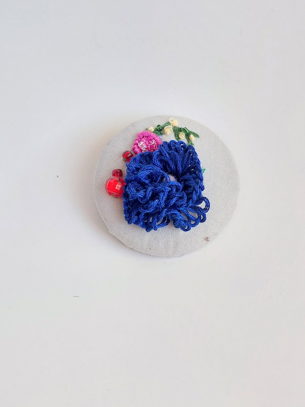 Decorative blue flower brooch on grey background