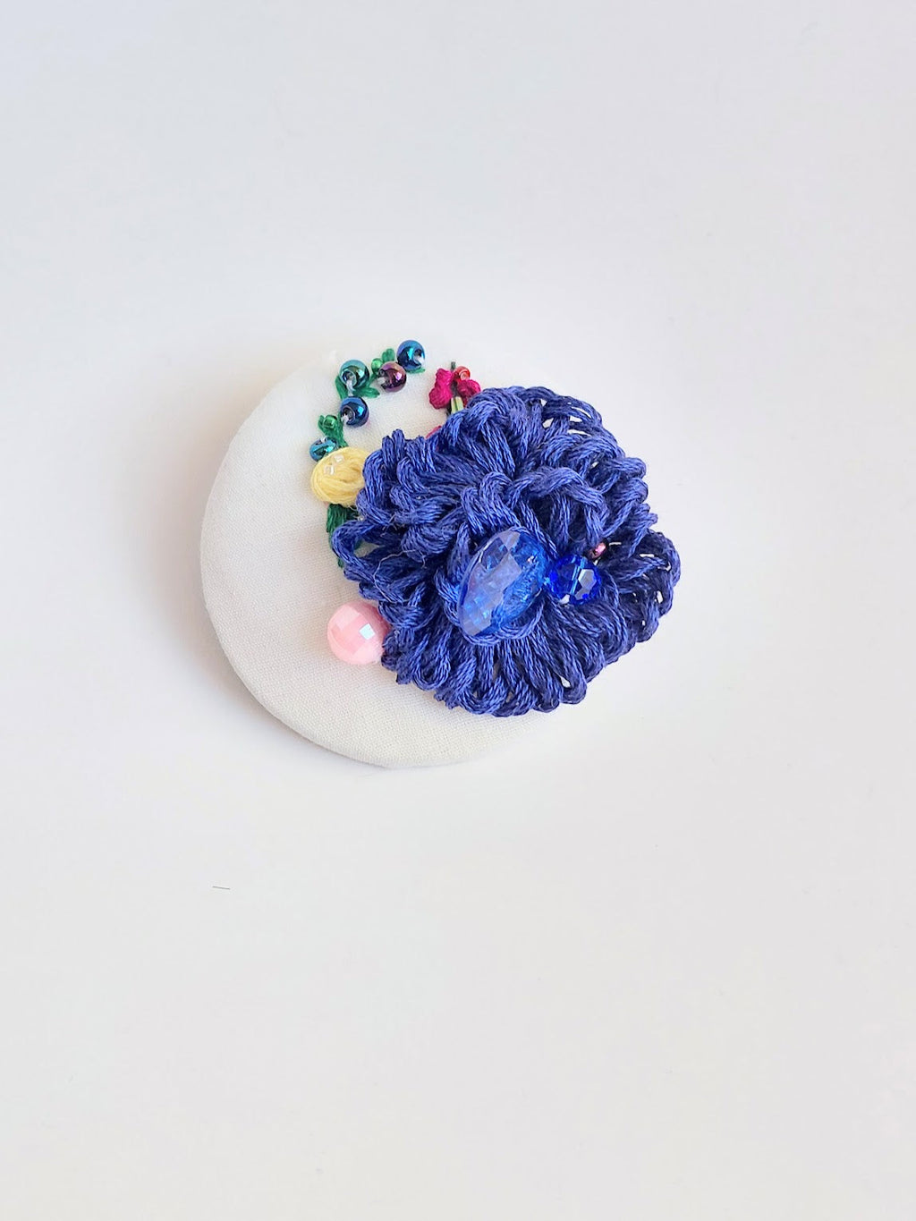 Decorative blue flower brooch on white background