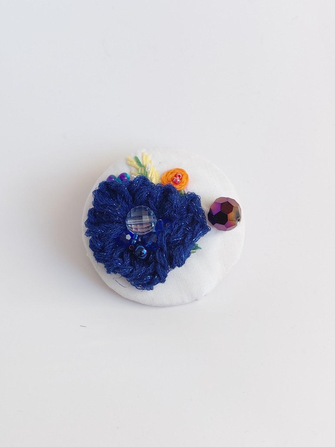 Decorative blue flower brooch on white background