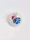 Decorative blue flower brooch on grey background