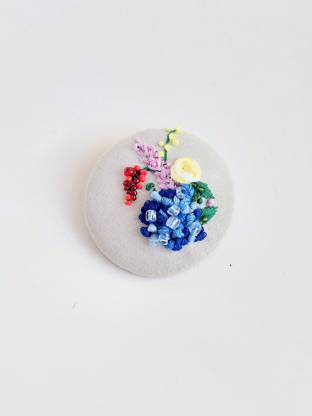 Decorative blue flower brooch on grey background