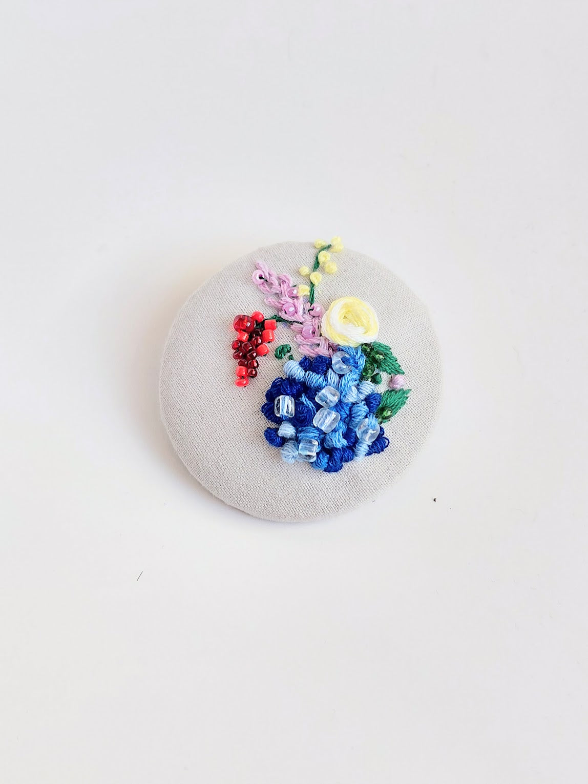 Decorative blue flower brooch on grey background