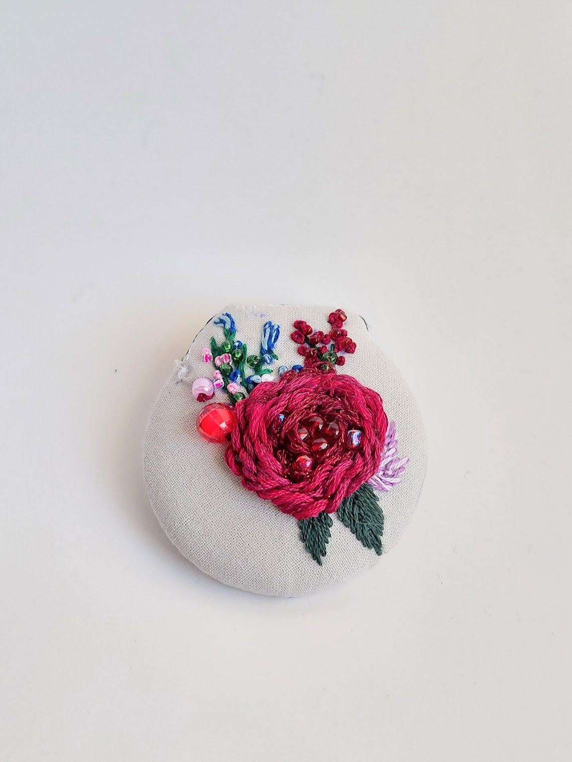 Decorative burgundy flower brooch on grey background