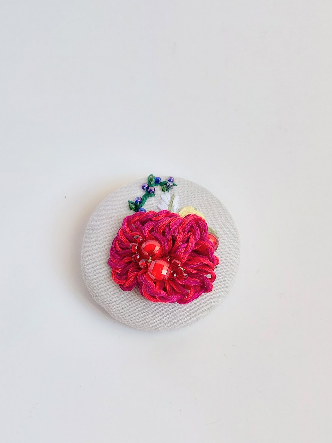 Decorative burgundy flower brooch on grey background