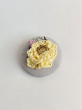 Decorative yellow flower brooch on grey background