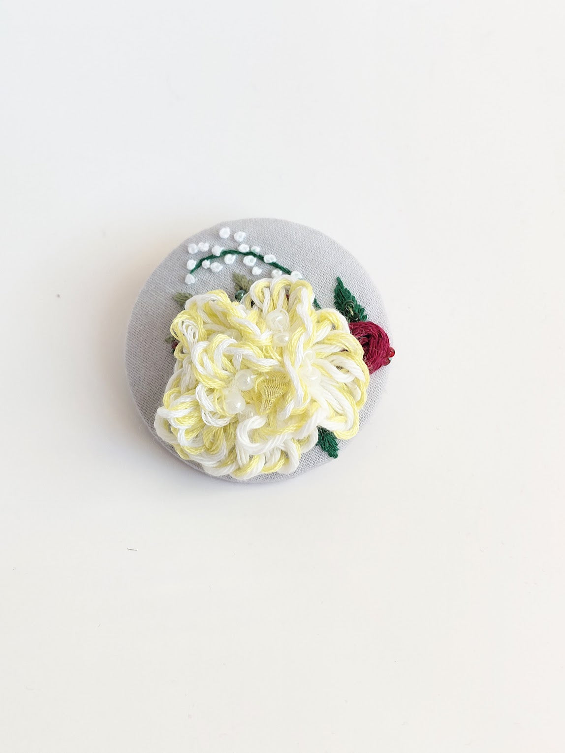 Decorative yellow flower brooch on grey background