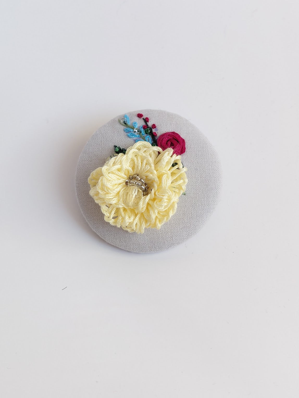 Decorative yellow flower brooch on grey background