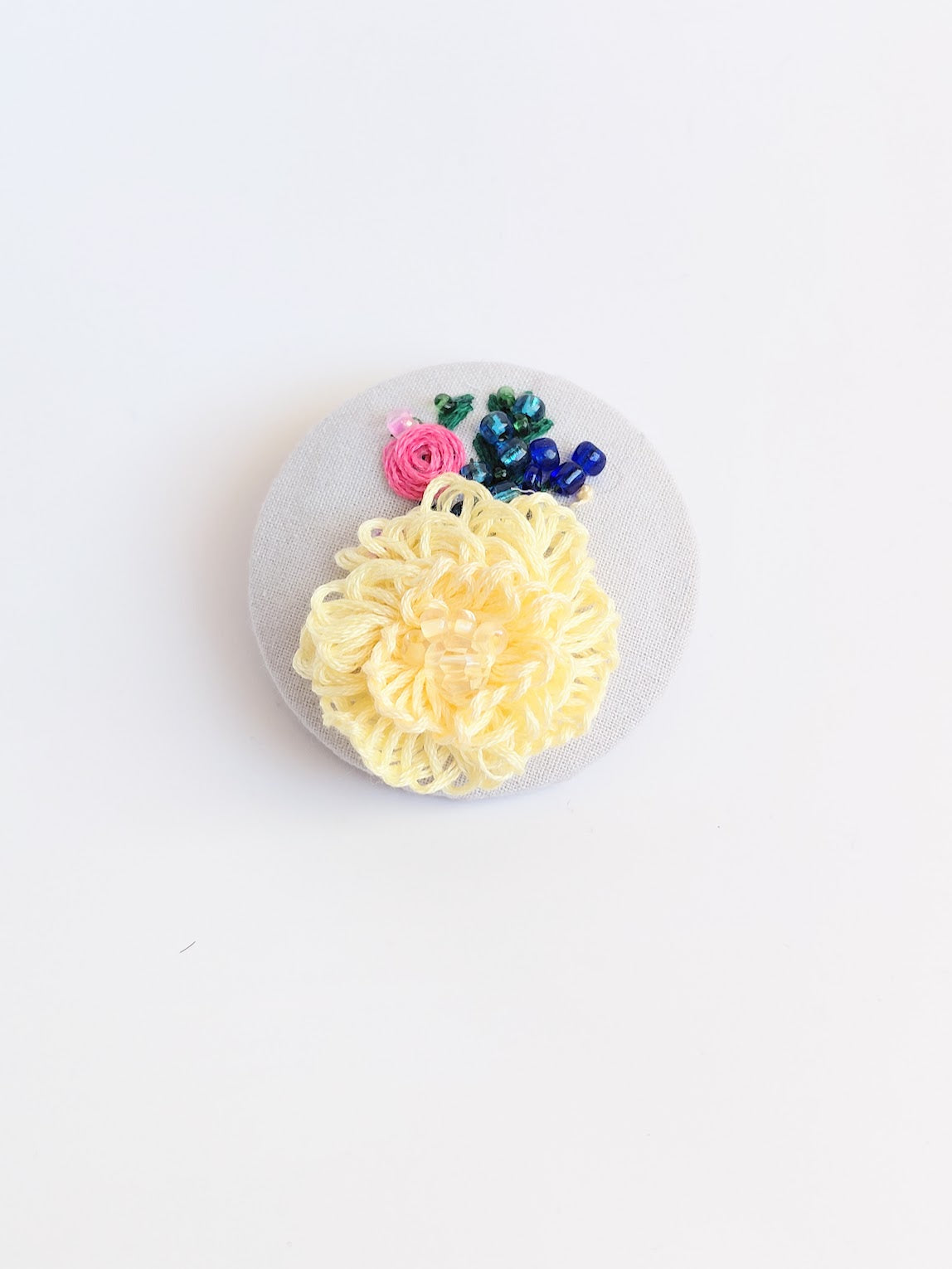 Decorative yellow flower brooch on grey background