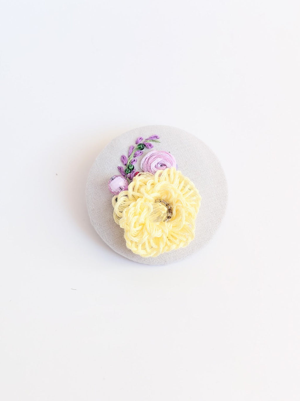 Decorative yellow flower brooch on grey background