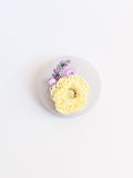 Decorative yellow flower brooch on grey background