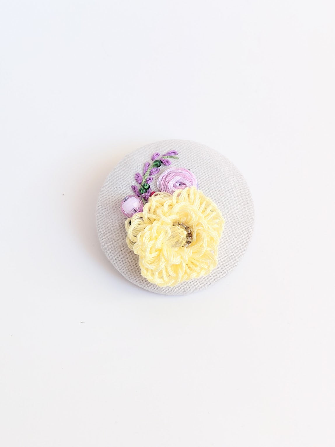 Decorative yellow flower brooch on grey background
