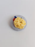 Decorative yellow flower brooch on grey background