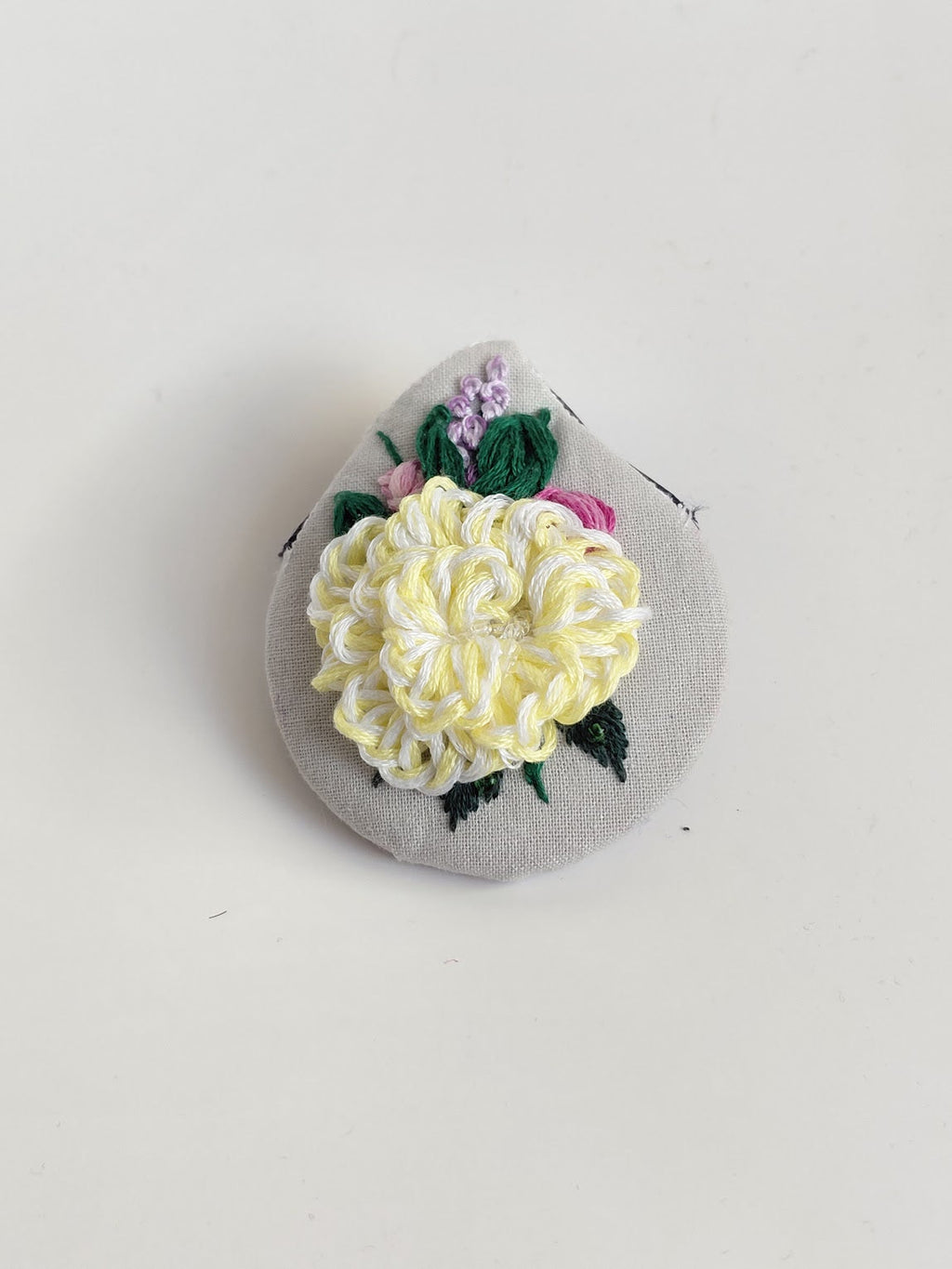 Decorative yellow flower brooch on grey background