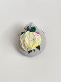 Decorative yellow flower brooch on grey background