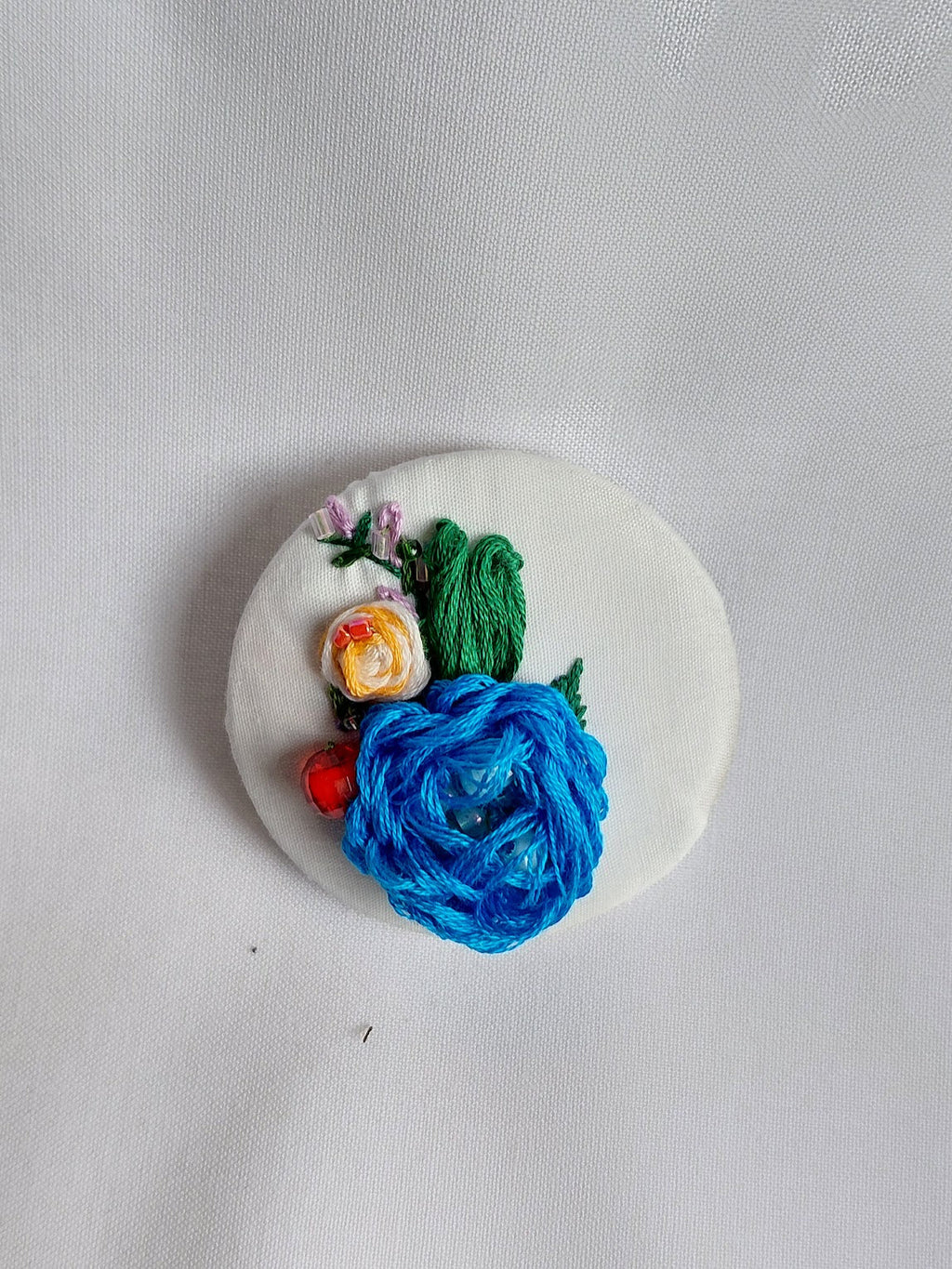 Decorative turquoise flower brooch on white background