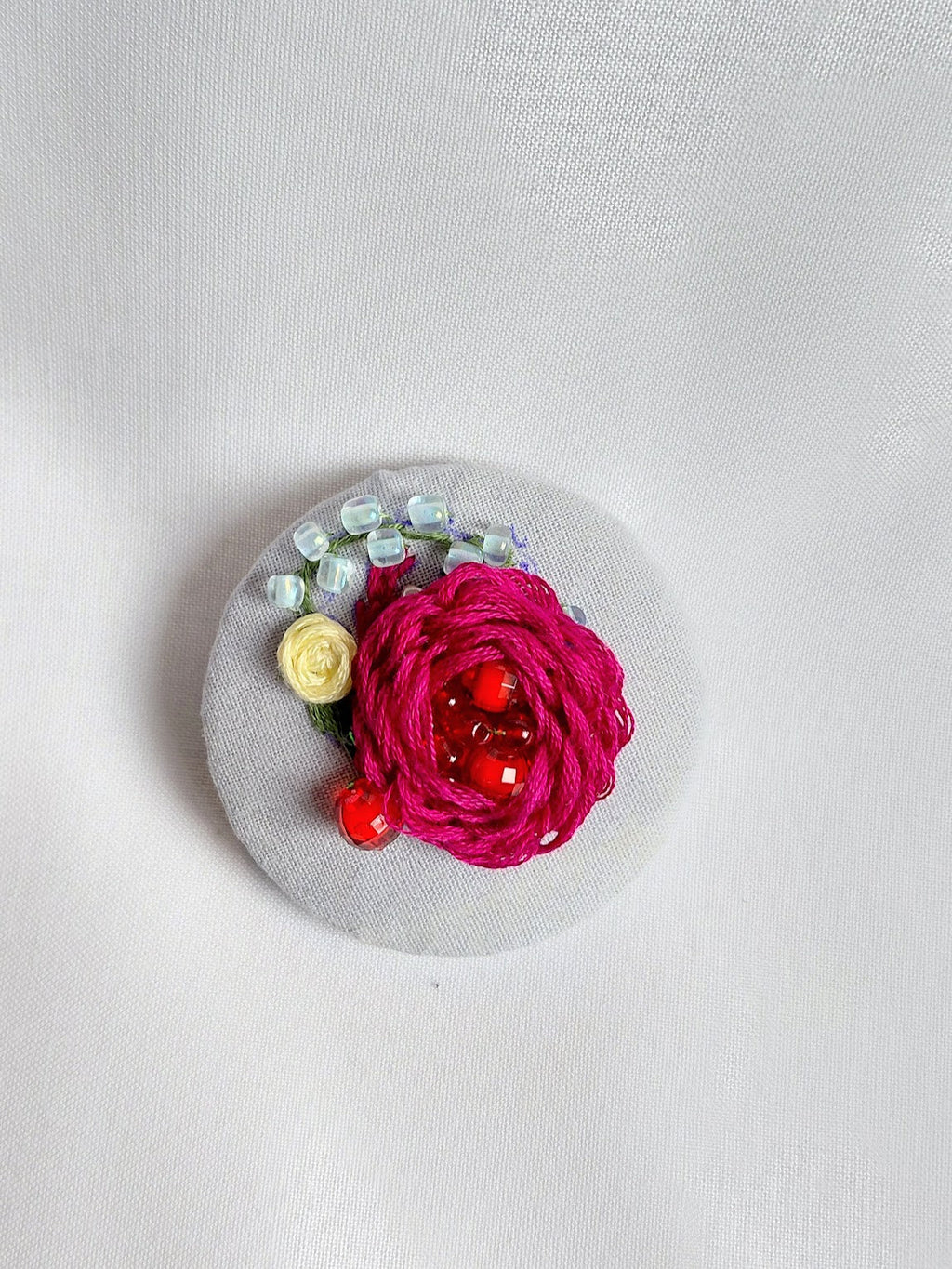 Decorative burgundy flower brooch on blue spec background