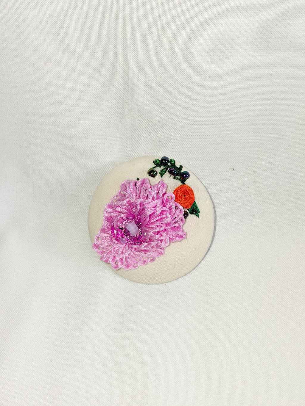 Decorative pink flower brooch on cream  background