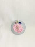 Decorative pink flower brooch on blue spec background