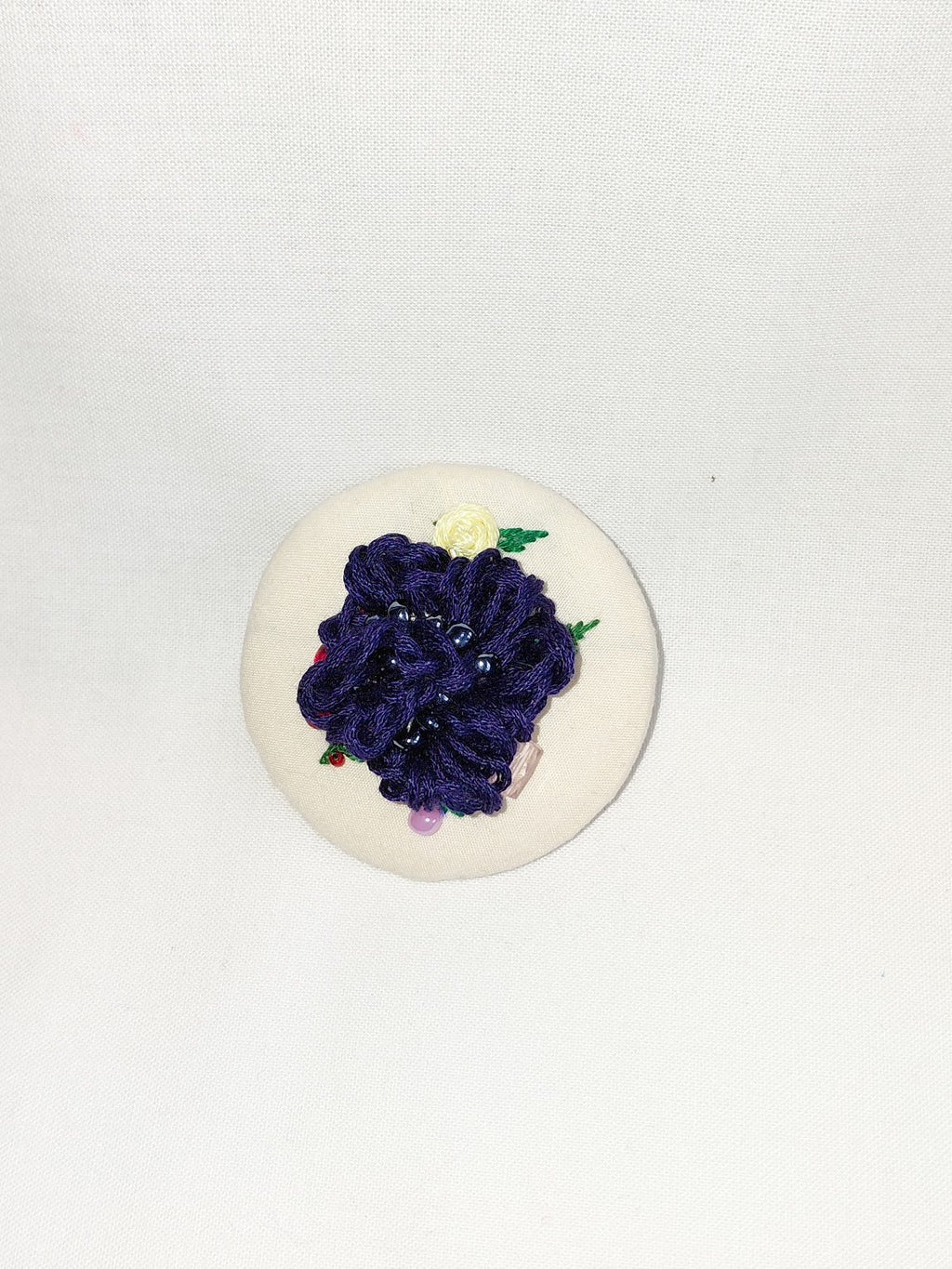 Decorative blue flower brooch on cream background