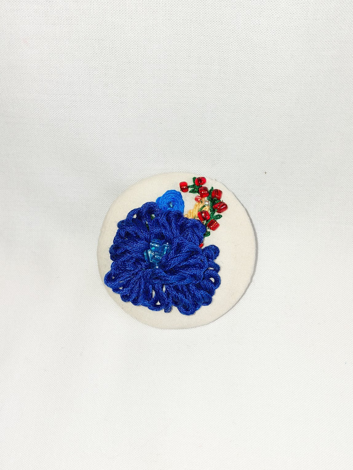 Decorative blue flower brooch on cream  background