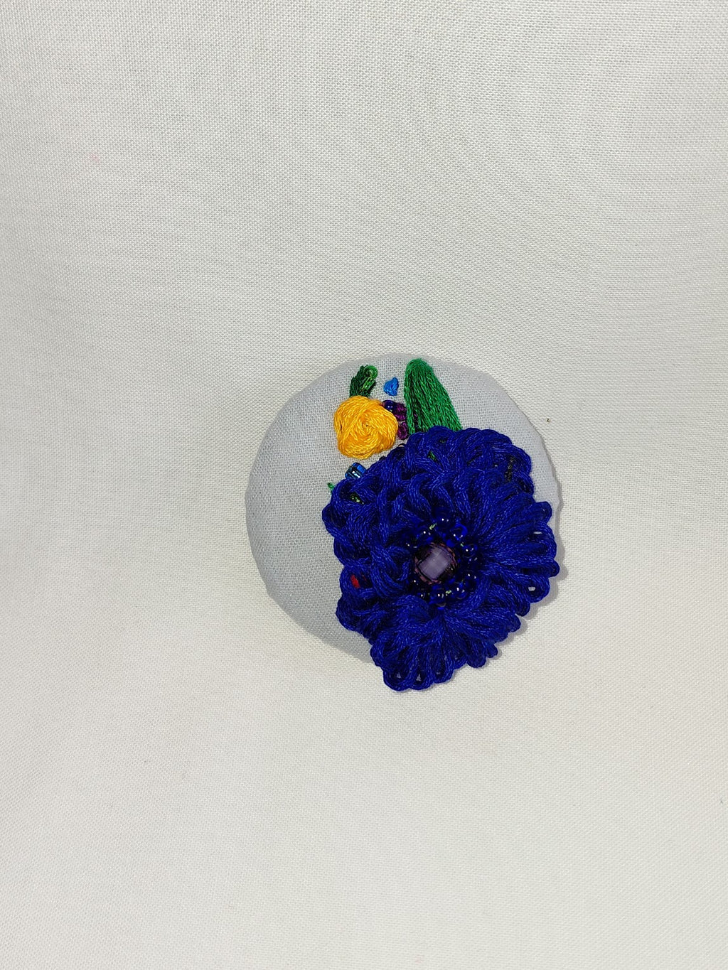 Decorative blue flower brooch on blue spec background