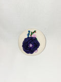 Decorative blue flower brooch on cream background