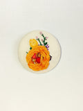 Decorative orange flower brooch on cream background