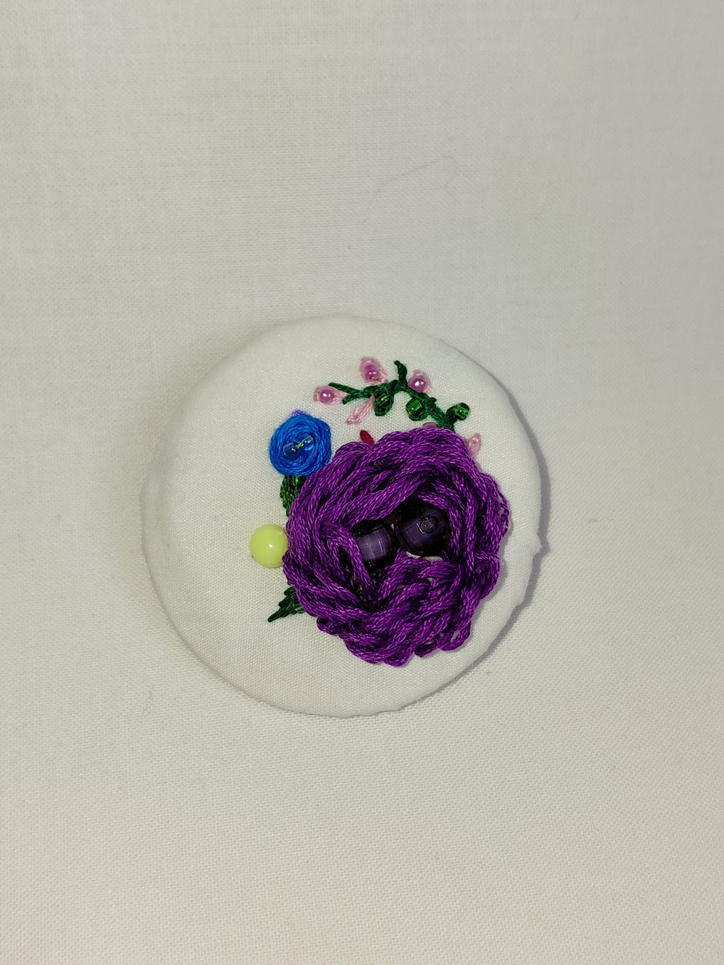 Decorative purple flower brooch on white  background