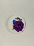 Decorative purple flower brooch on white  background