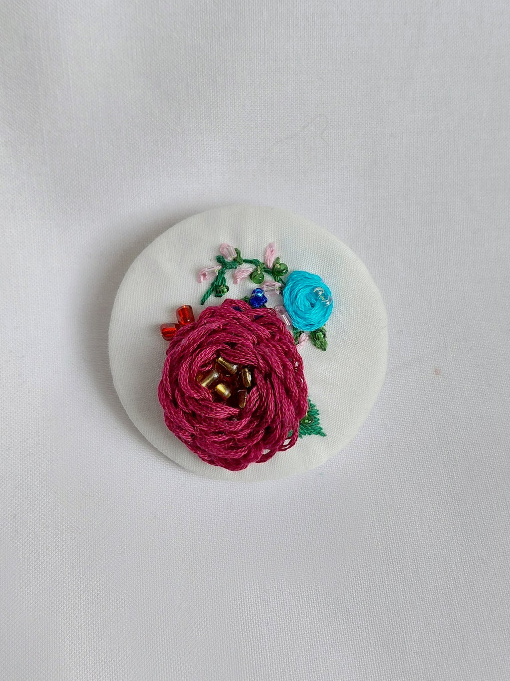 Decorative purple flower brooch on white background