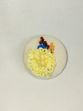 Decorative yellow flower brooch on cream background