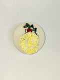 Decorative yellow flower brooch on cream background