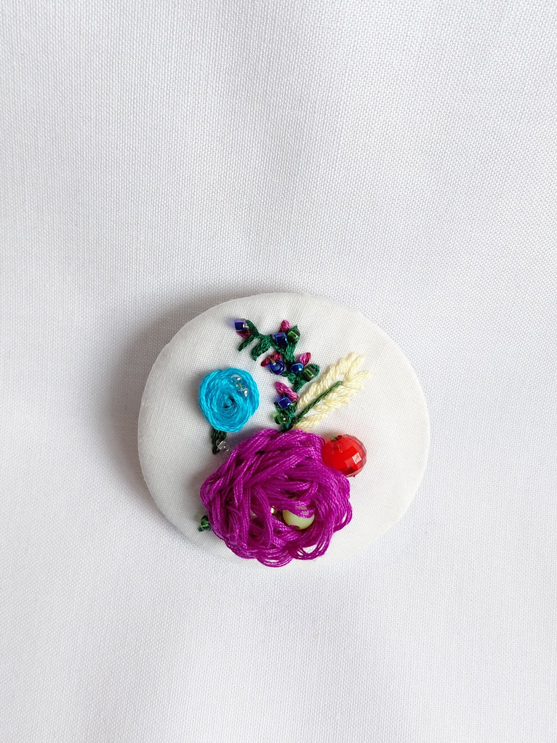 Decorative fuschia flower brooch on white background
